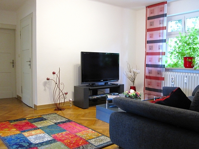 Wohndiele Mit Bequemer Couch, Teppich Und TV Flachbildschirm Und Großer Zimmerpflanze