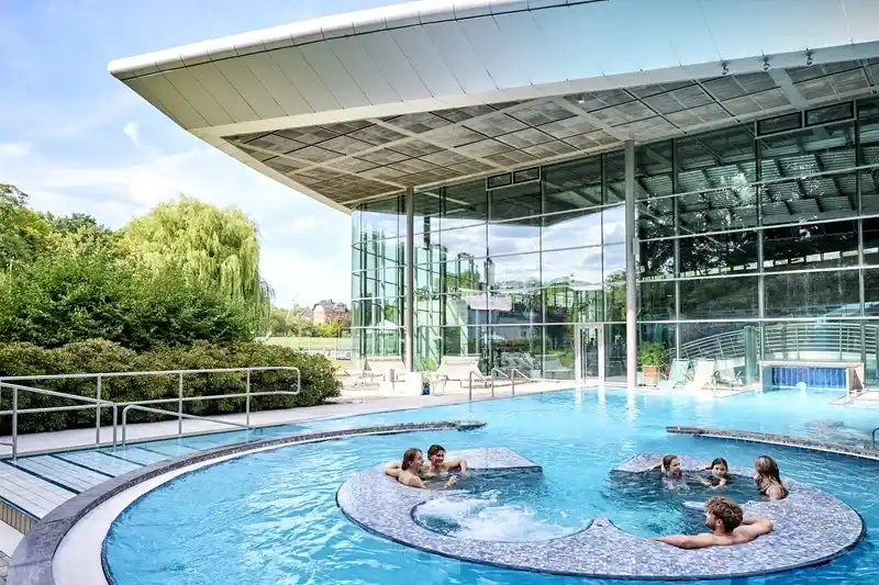 Außenbecken der Ardesia-Therme mit großer Glasfassade im Hintergrund